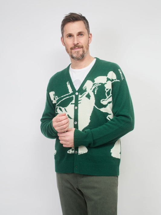 Man wearing a green cardigan with a white graphic design on a plain background