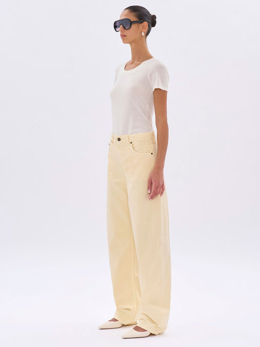 Woman wearing a white top and light yellow pants on a white background