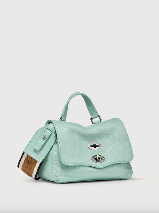 Light blue handbag with decorative elements on a light gray background