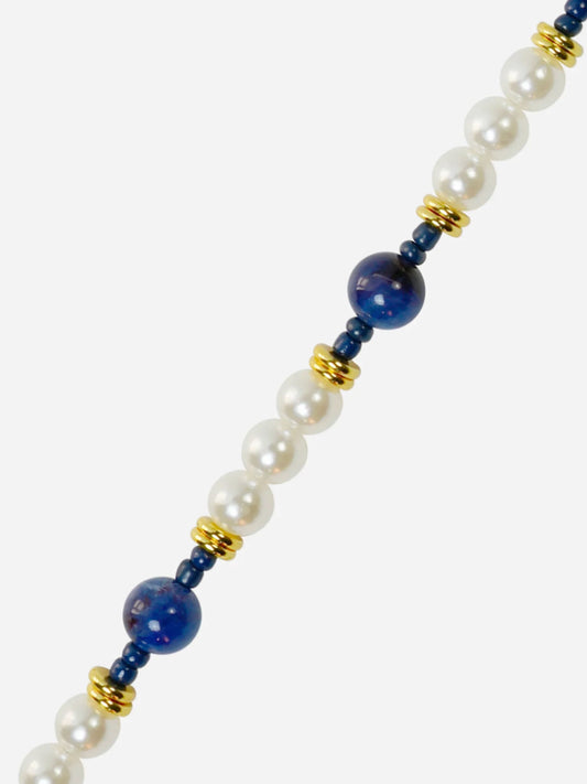 phone chain with white pearls, blue beads, and gold accents on a white background