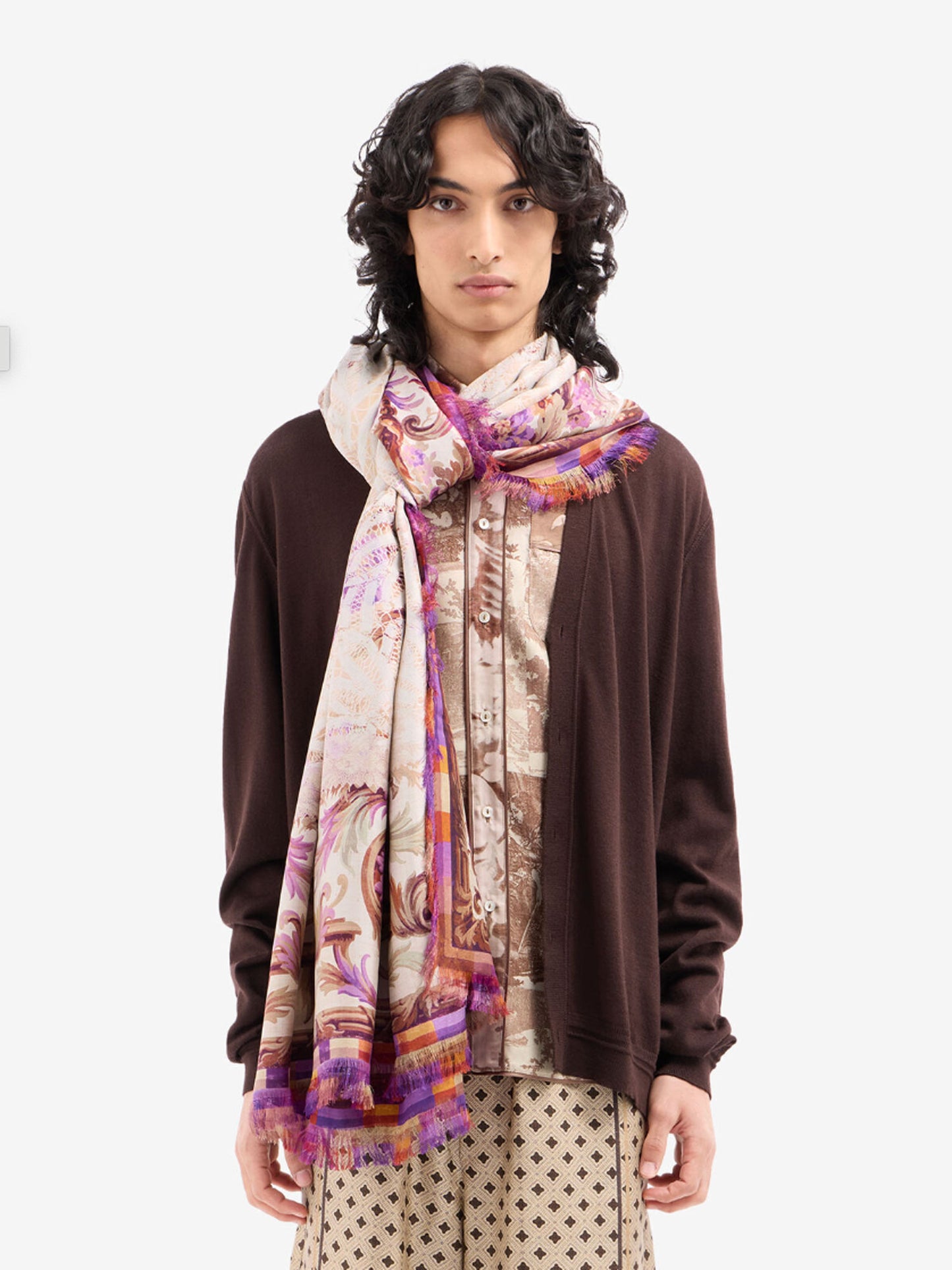 Person wearing a patterned scarf on a white background