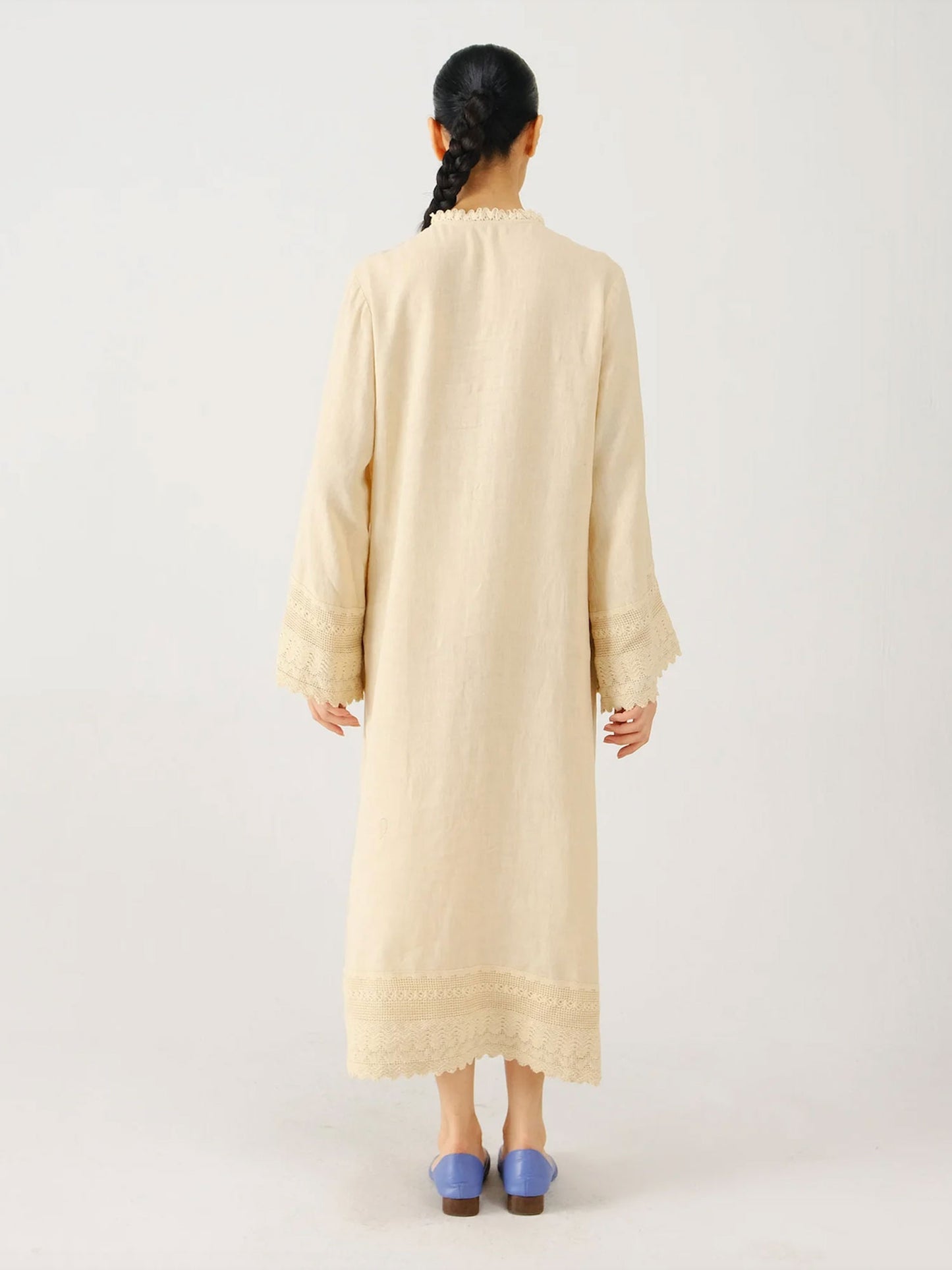 Woman wearing a beige long dress on a white background
