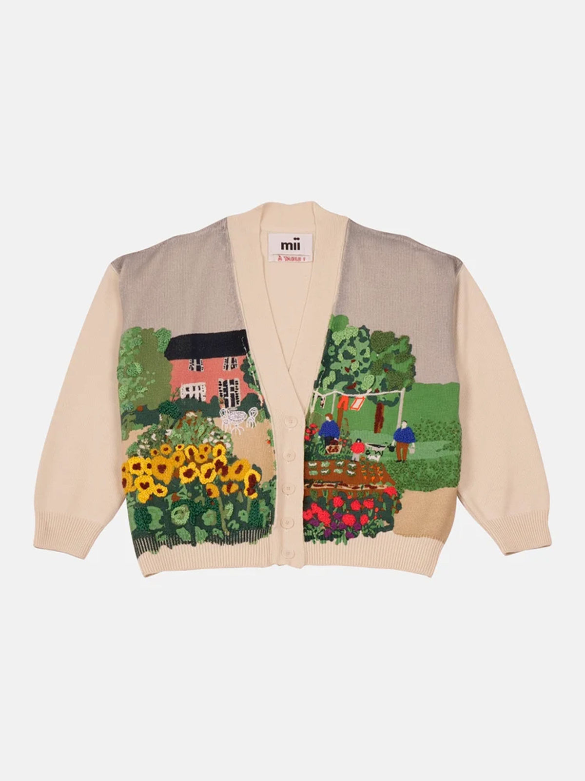 A cream-colored knit cardigan by mii Mii featuring a colorful embroidered garden and cottage motif on the front, displayed against a light gray background.