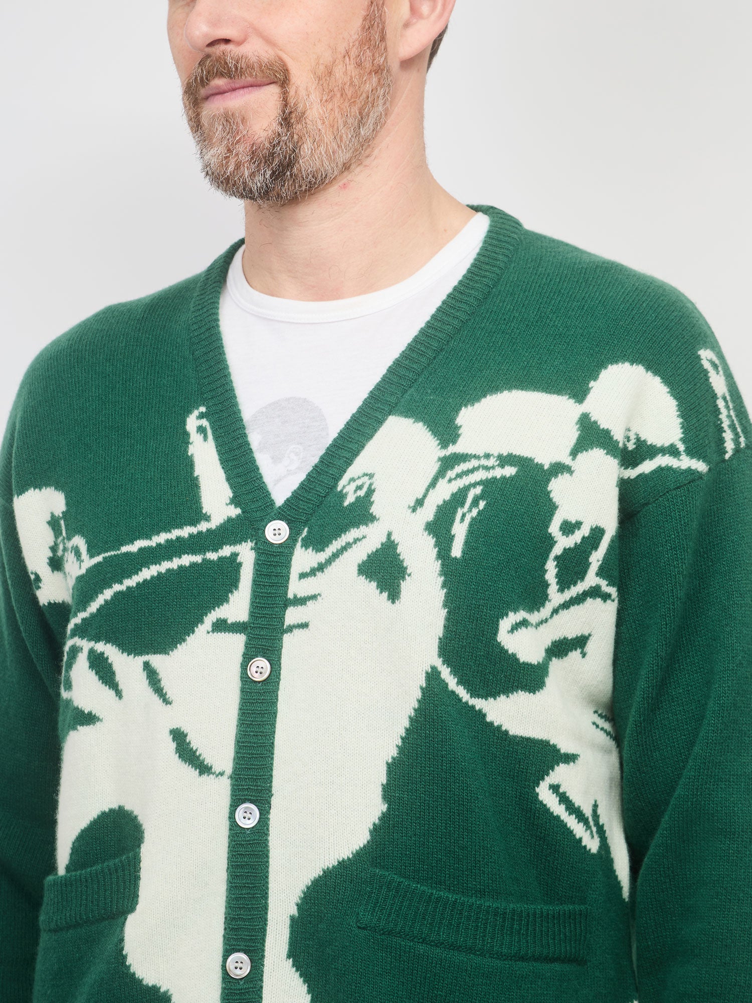 Green cardigan with bear design worn by a person on a white background