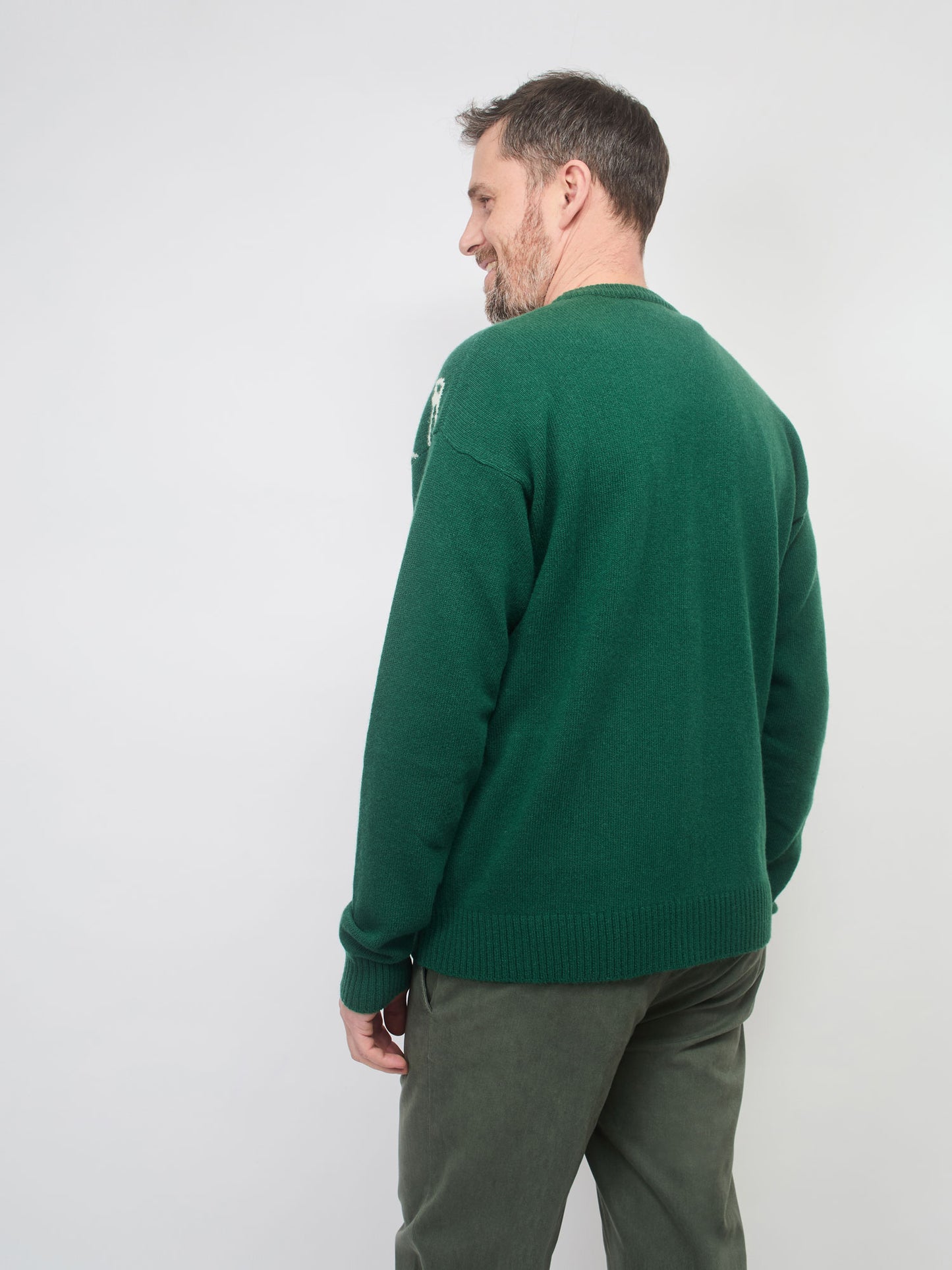 Man wearing a green sweater against a white background