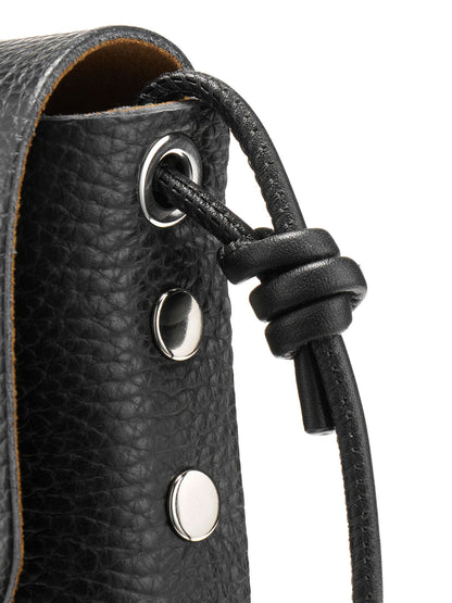 Close-up of a black pebbled leather bag with silver-tone metal grommets and a black leather drawstring tied in a knot, on a white background.