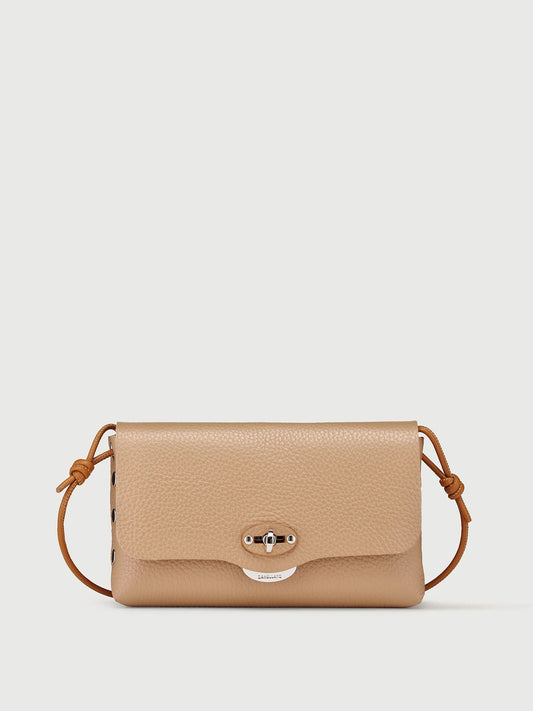 A beige pebbled leather crossbody bag with a matching adjustable leather strap and a silver-tone turn-lock closure on the front flap, shown against a light gray background.
