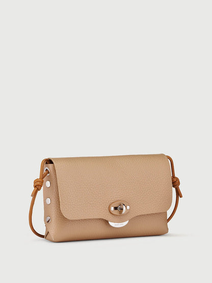 A small tan pebbled leather crossbody bag with a flap closure, silver-tone hardware, and a thin brown leather strap, shown on a light gray background.