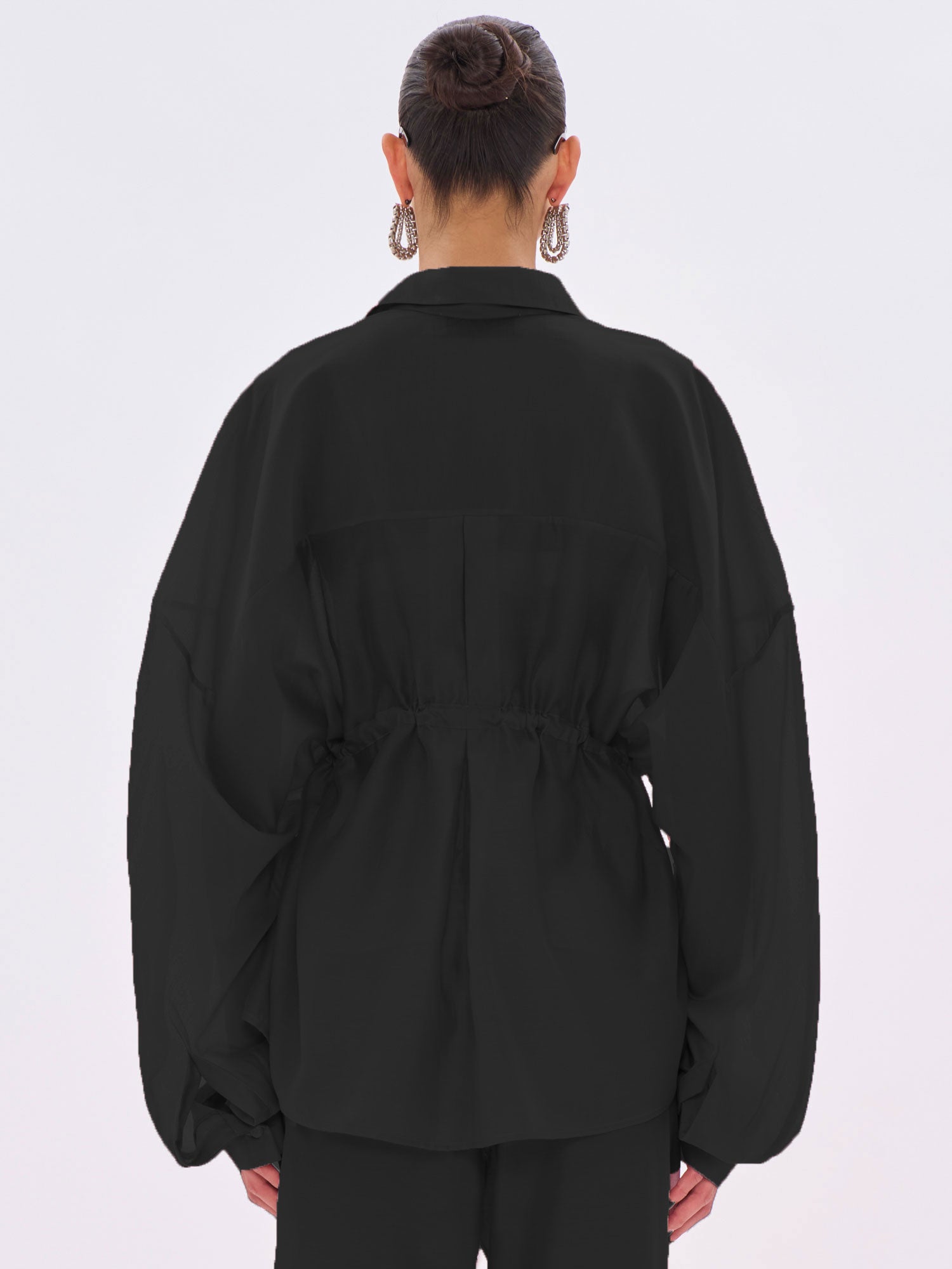 Person wearing a black jacket on a white background