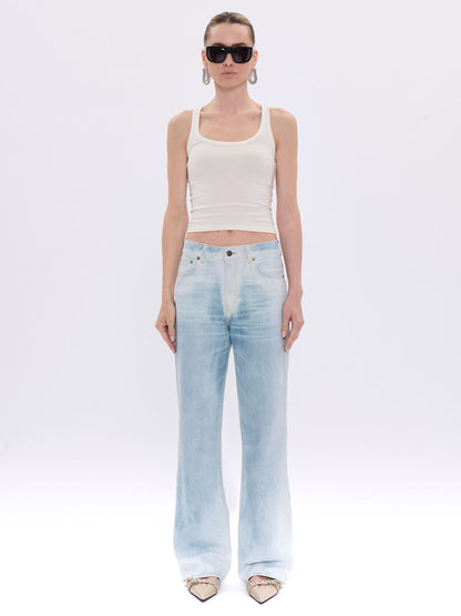 Woman wearing a white tank top and light blue jeans on a white background
