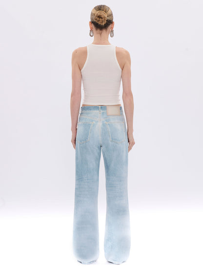 Person wearing light blue jeans and a white sleeveless top on a white background