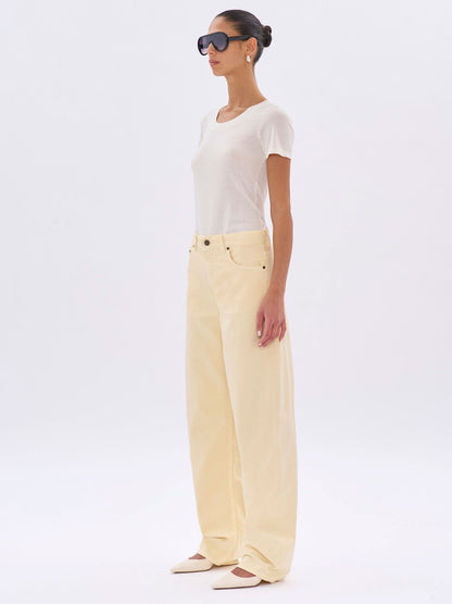 Woman wearing a white top and light yellow pants on a white background