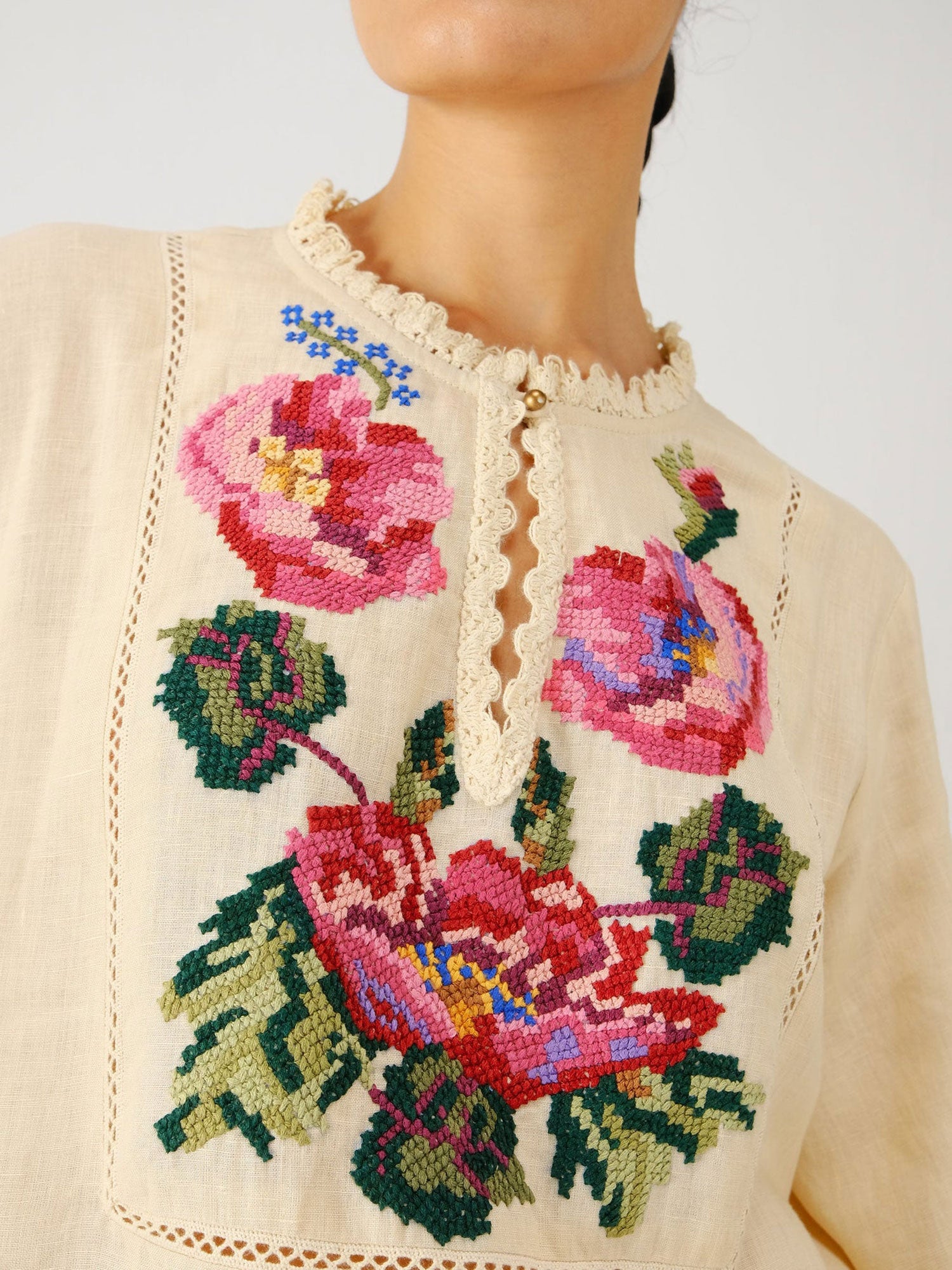 Close-up of a garment with floral embroidery on a plain background