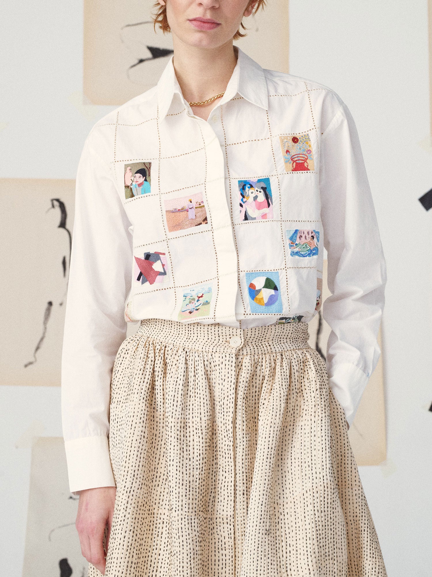 Person wearing a white shirt with a colorful patchwork vest over a beige skirt.