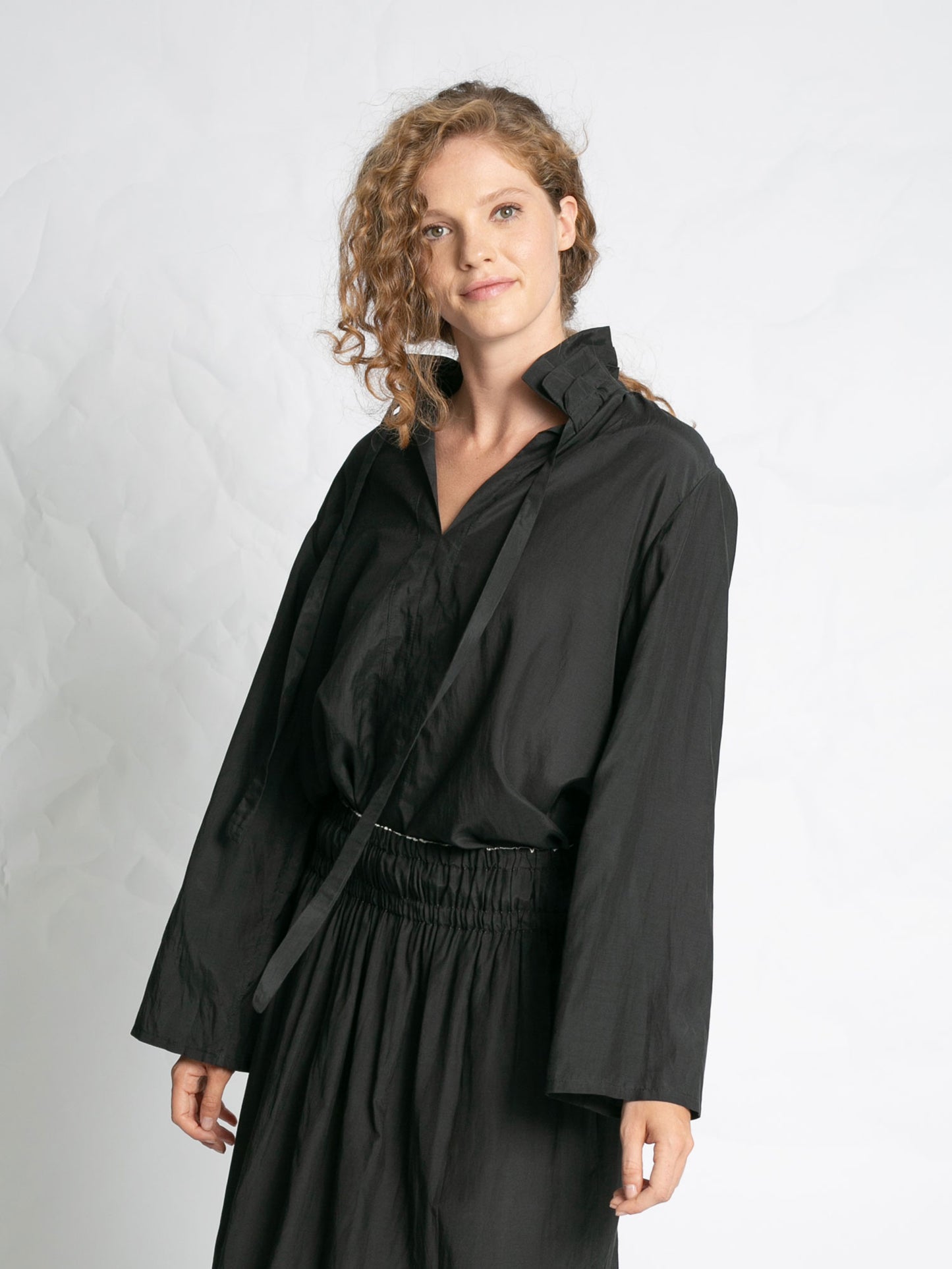 Woman wearing a black outfit against a plain background