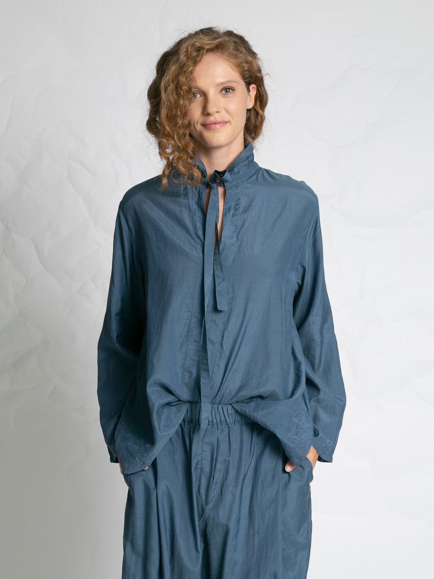 Woman wearing a blue outfit against a plain background