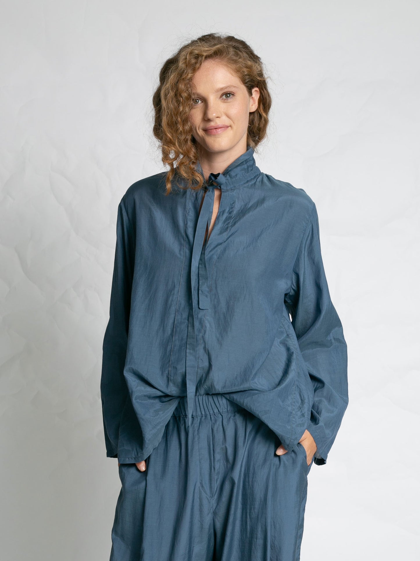 Woman wearing a blue outfit against a plain background