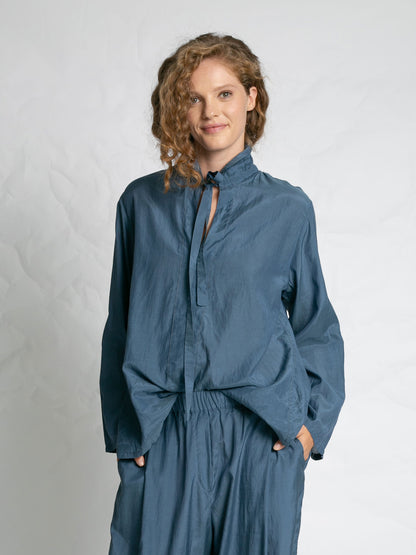 Woman wearing a blue outfit against a plain background