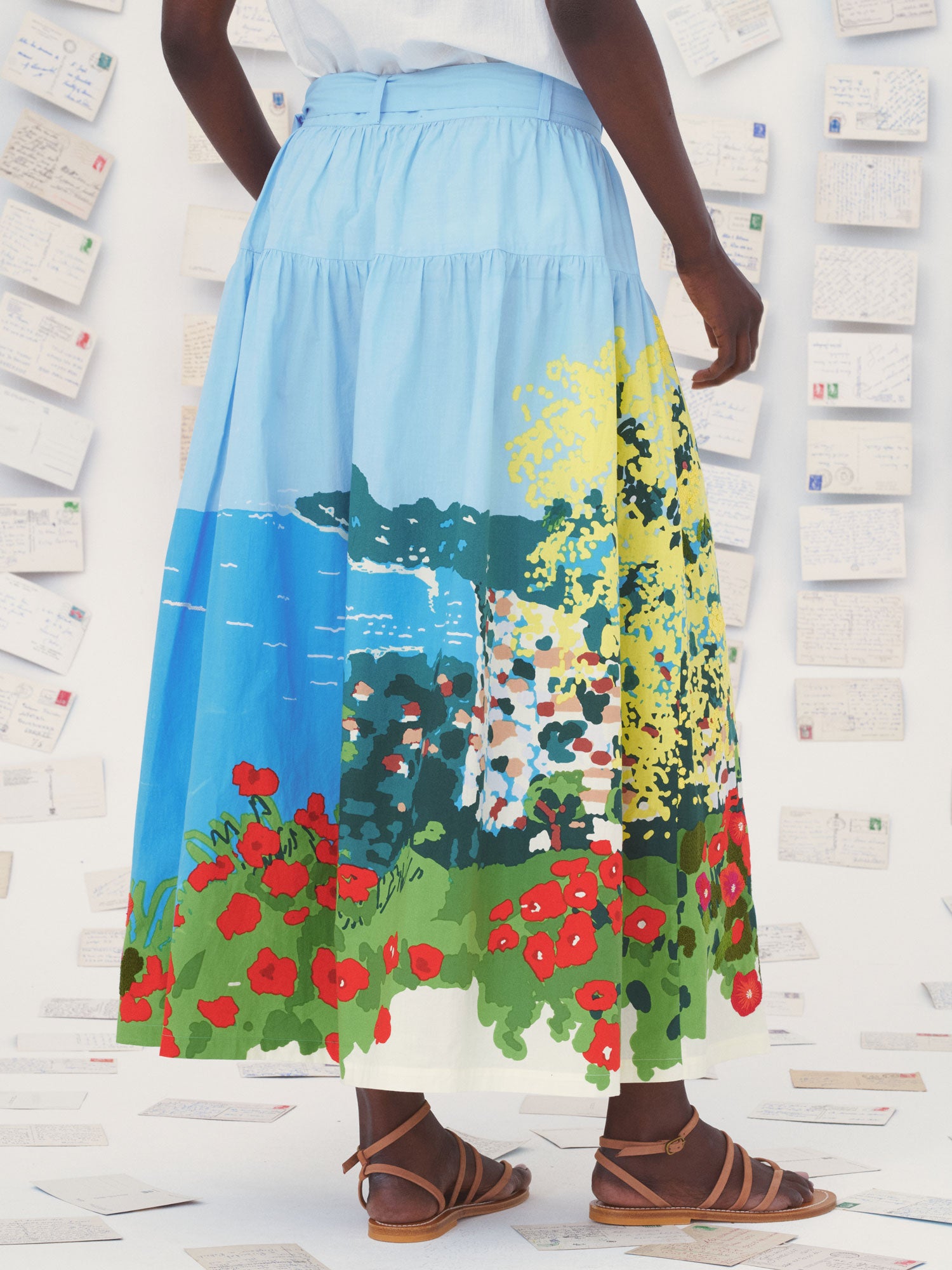 Person wearing a colorful Mii skirt with nature design in an indoor setting