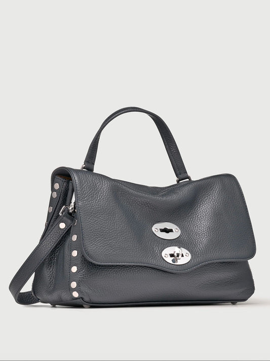 Black leather handbag with silver hardware on a light gray background