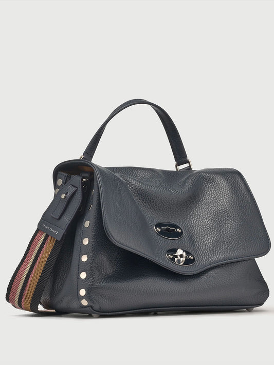 Black navy leather handbag with a strap on a light gray background