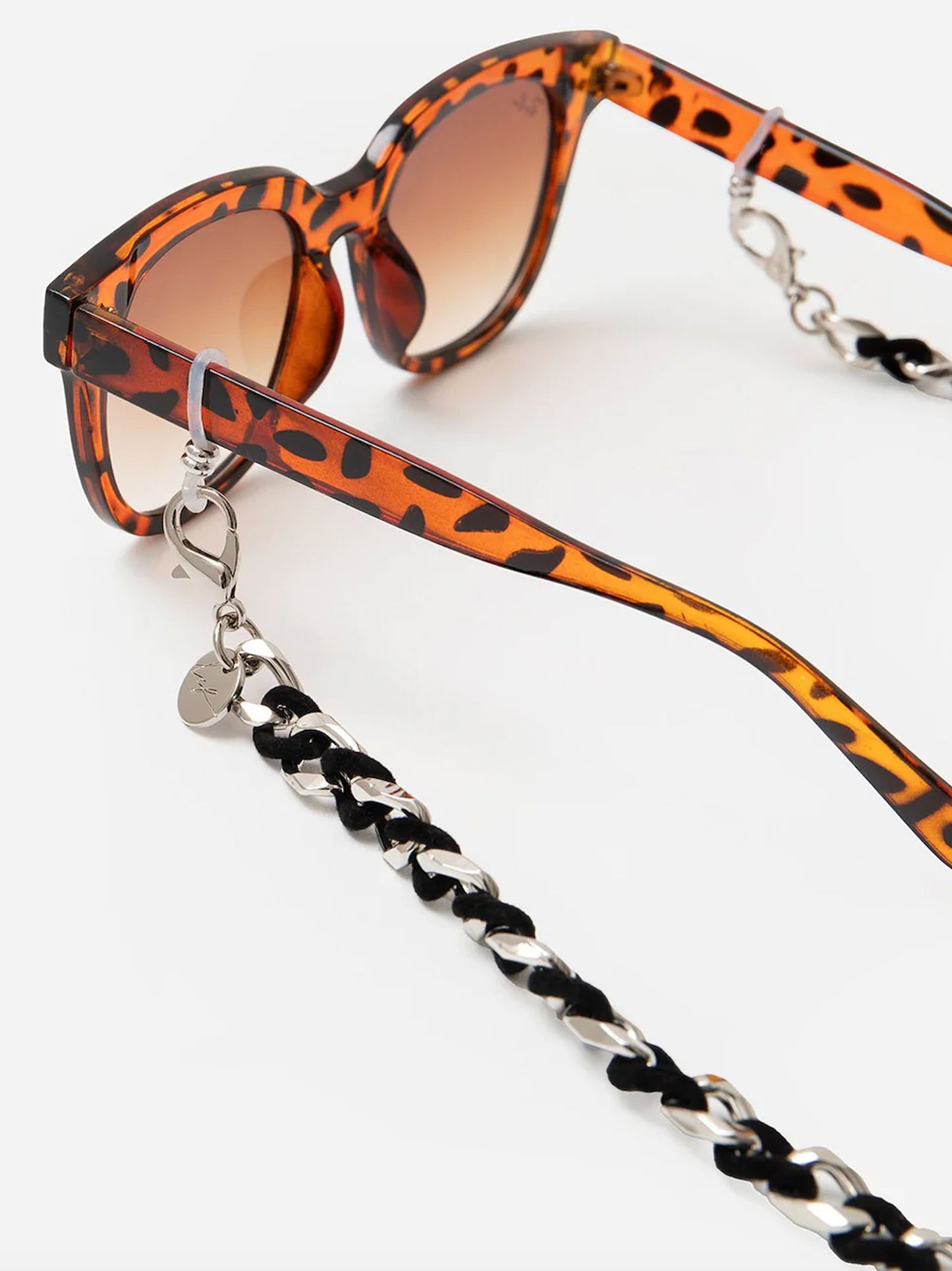 Sunglasses with a braided black and white strap on a white background