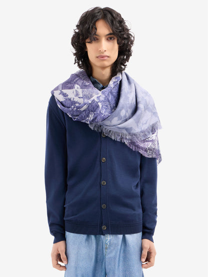 Person wearing a navy blue cardigan and light blue pants with a blue floral scarf.