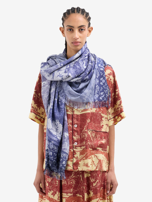 Woman wearing a patterned scarf and outfit on a white background