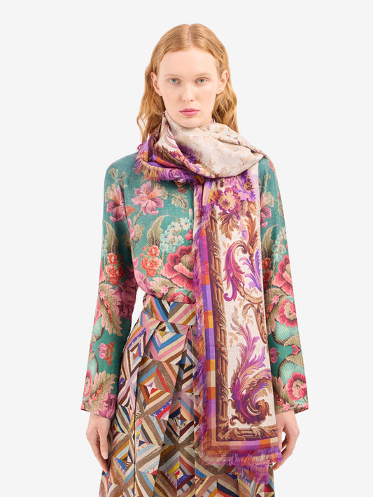 Woman wearing a colorful patterned scarf and dress on a white background