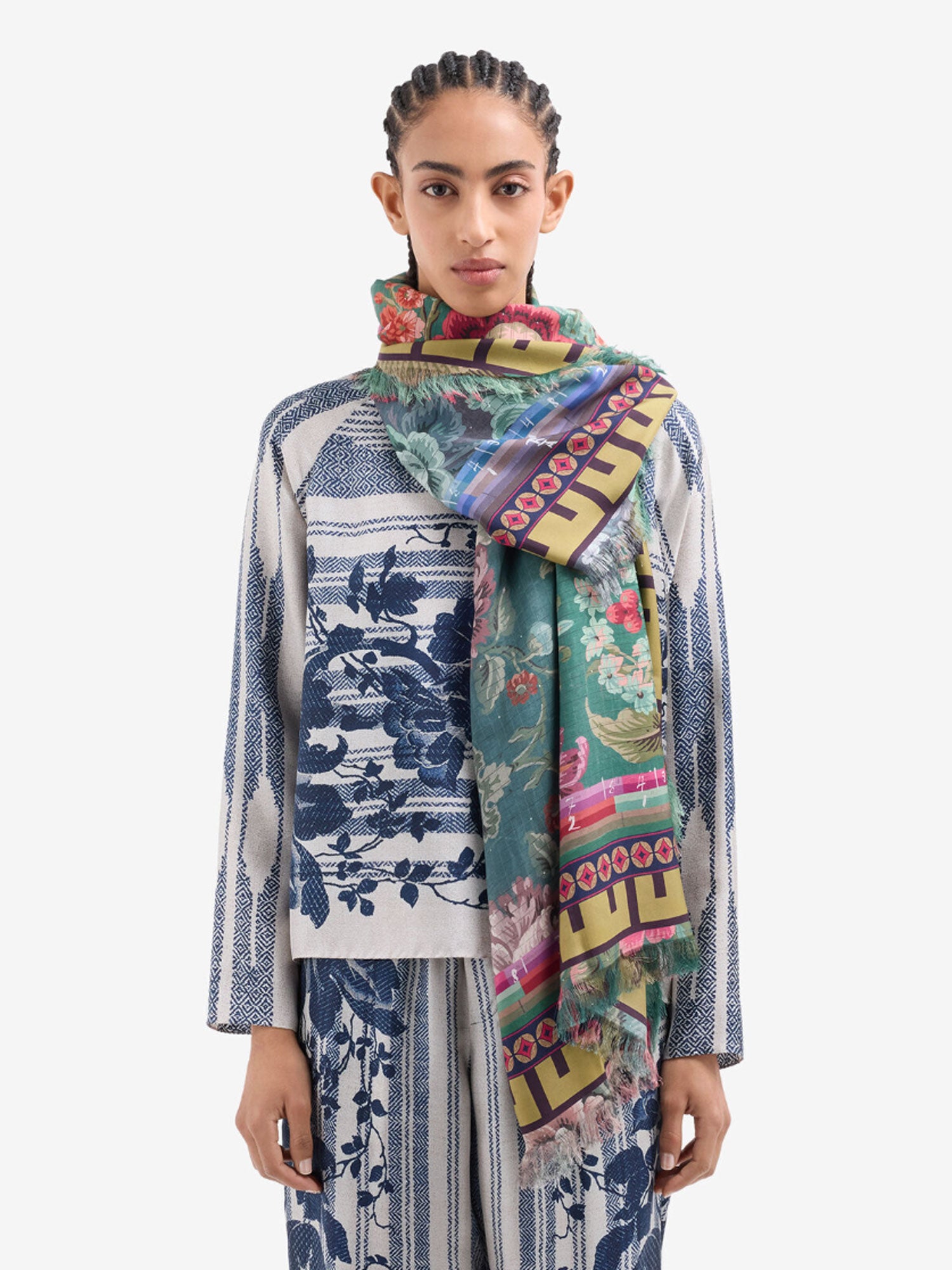 Woman wearing a colorful scarf with a patterned outfit on a white background