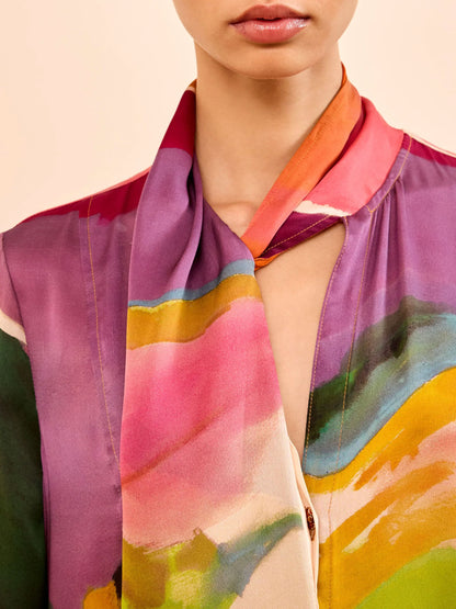 Person wearing a colorful dress with abstract patterns on a beige background