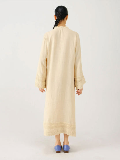 Woman wearing a beige long dress on a white background