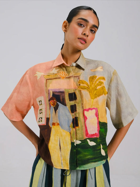 Person wearing a colorful, patterned shirt with abstract designs on a plain background