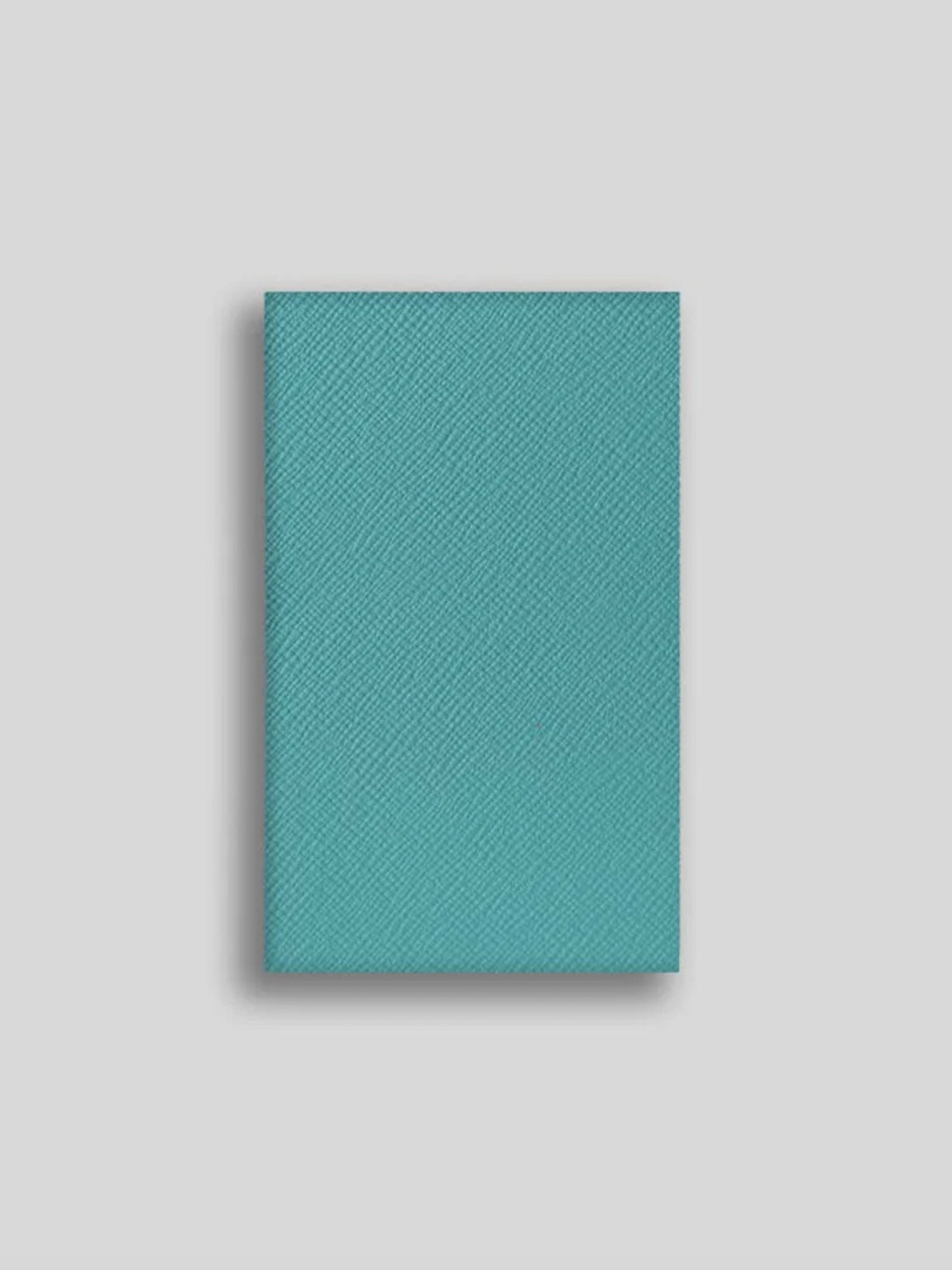 Teal textured notebook on a light gray background