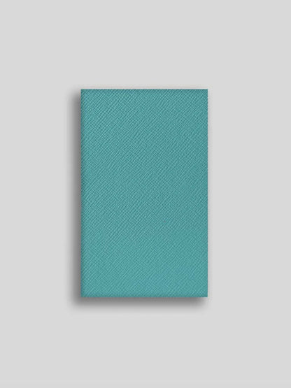 Teal textured notebook on a light gray background