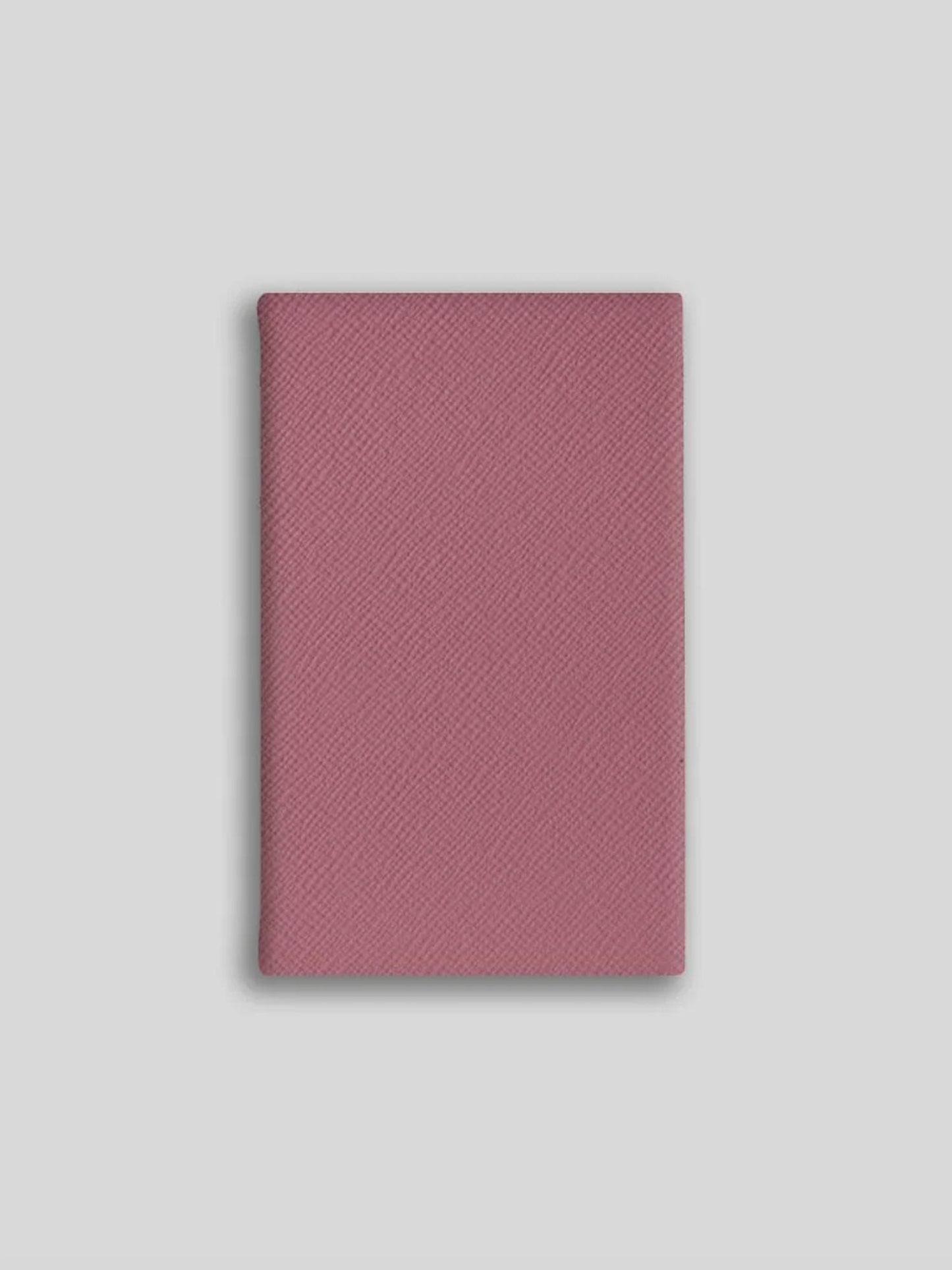 Pink textured notebook on a light gray background