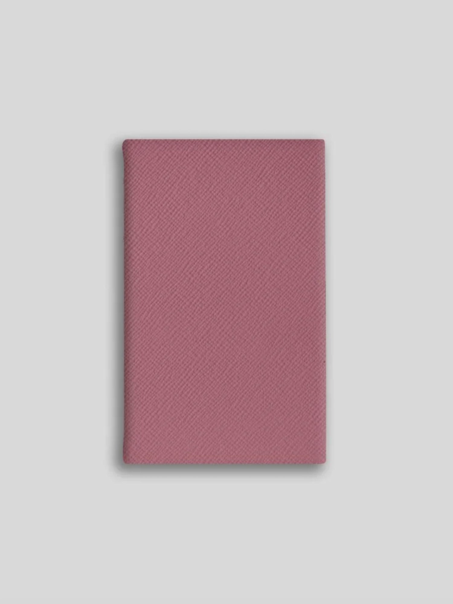 Pink textured notebook on a light gray background