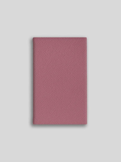 Pink textured notebook on a light gray background