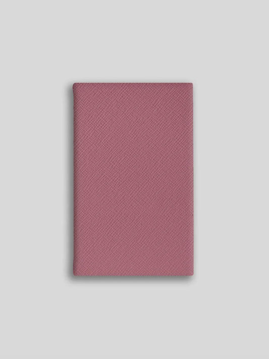 Pink textured notebook on a light gray background
