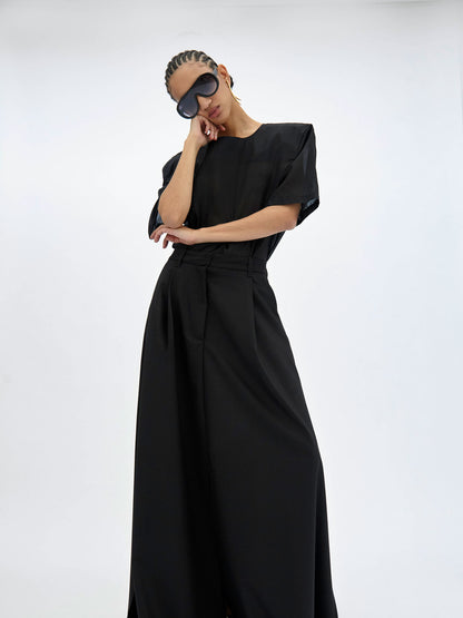 Woman wearing a black top with a plain background