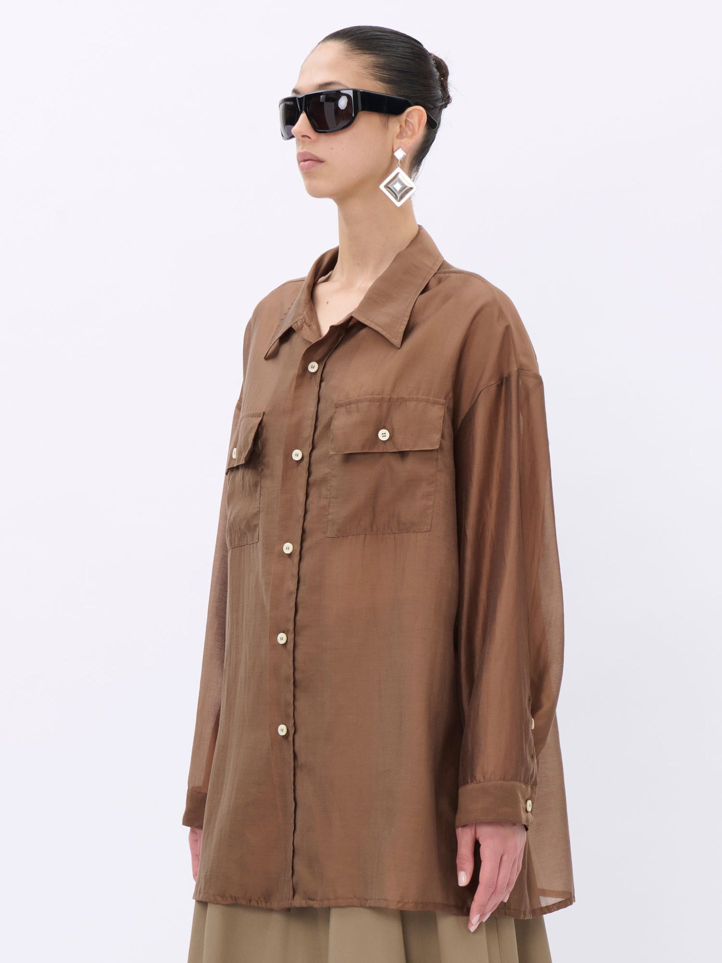 Woman wearing a brown shirt with a neutral background