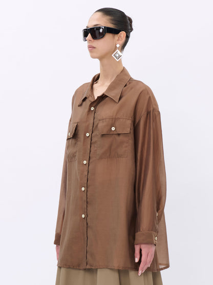 Woman wearing a brown shirt with a neutral background