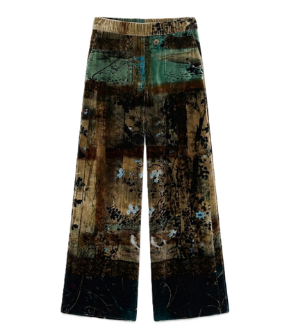 A pair of wide-leg trousers featuring a complex abstract patchwork print with brown, green, black, and blue tones, displayed flat against a solid white background.