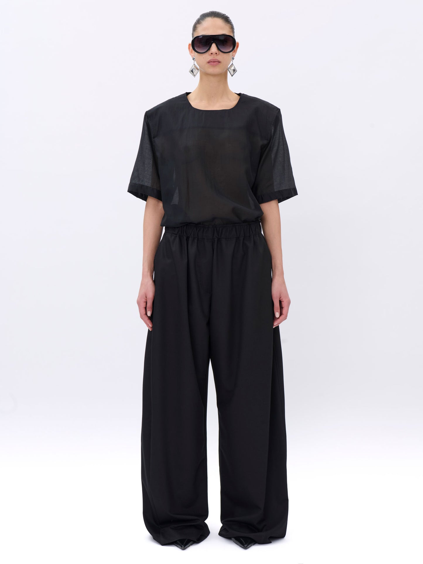 Person wearing a black outfit on a white background