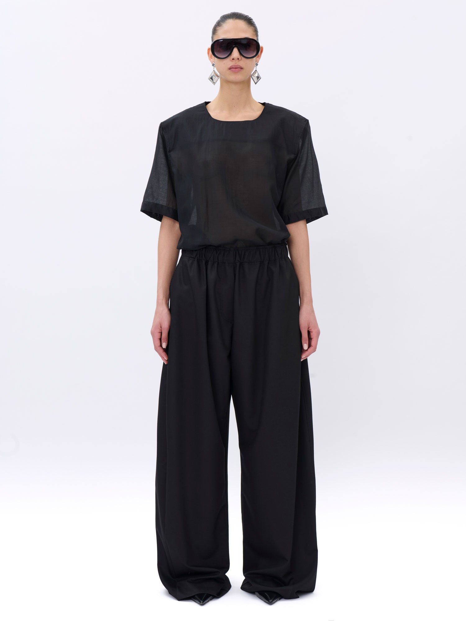 Person wearing a black outfit on a white background