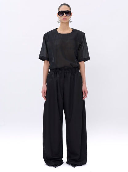 Person wearing a black outfit on a white background