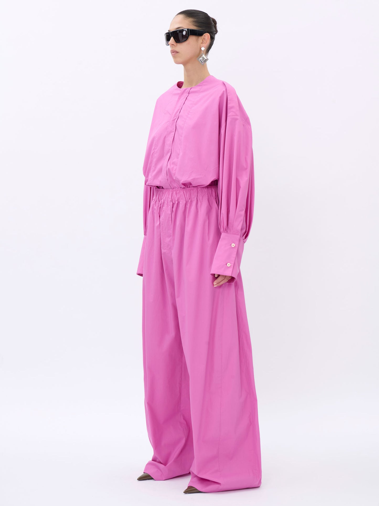 Person wearing a pink outfit on a white background