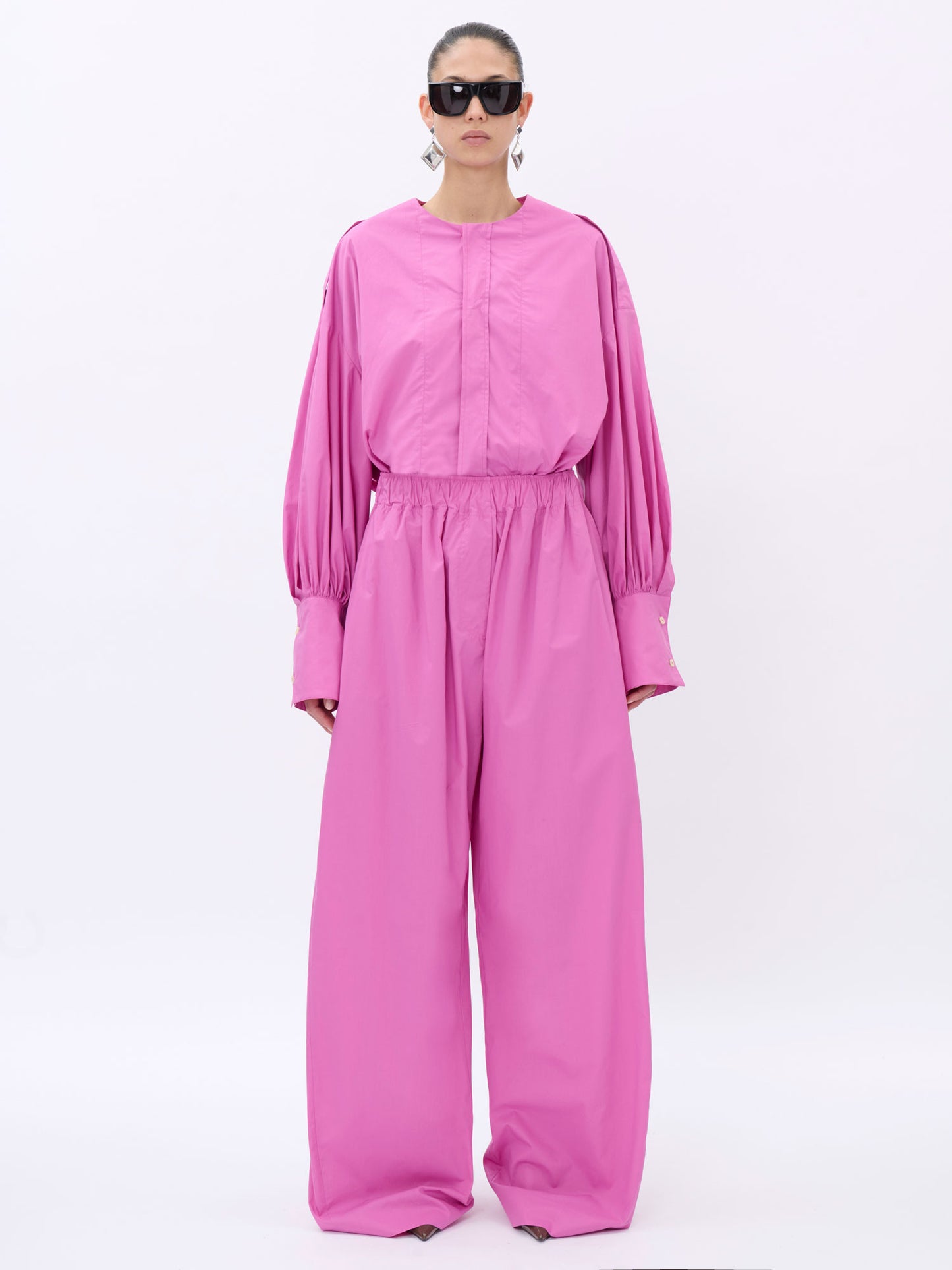 Person wearing a pink shirt on a white background