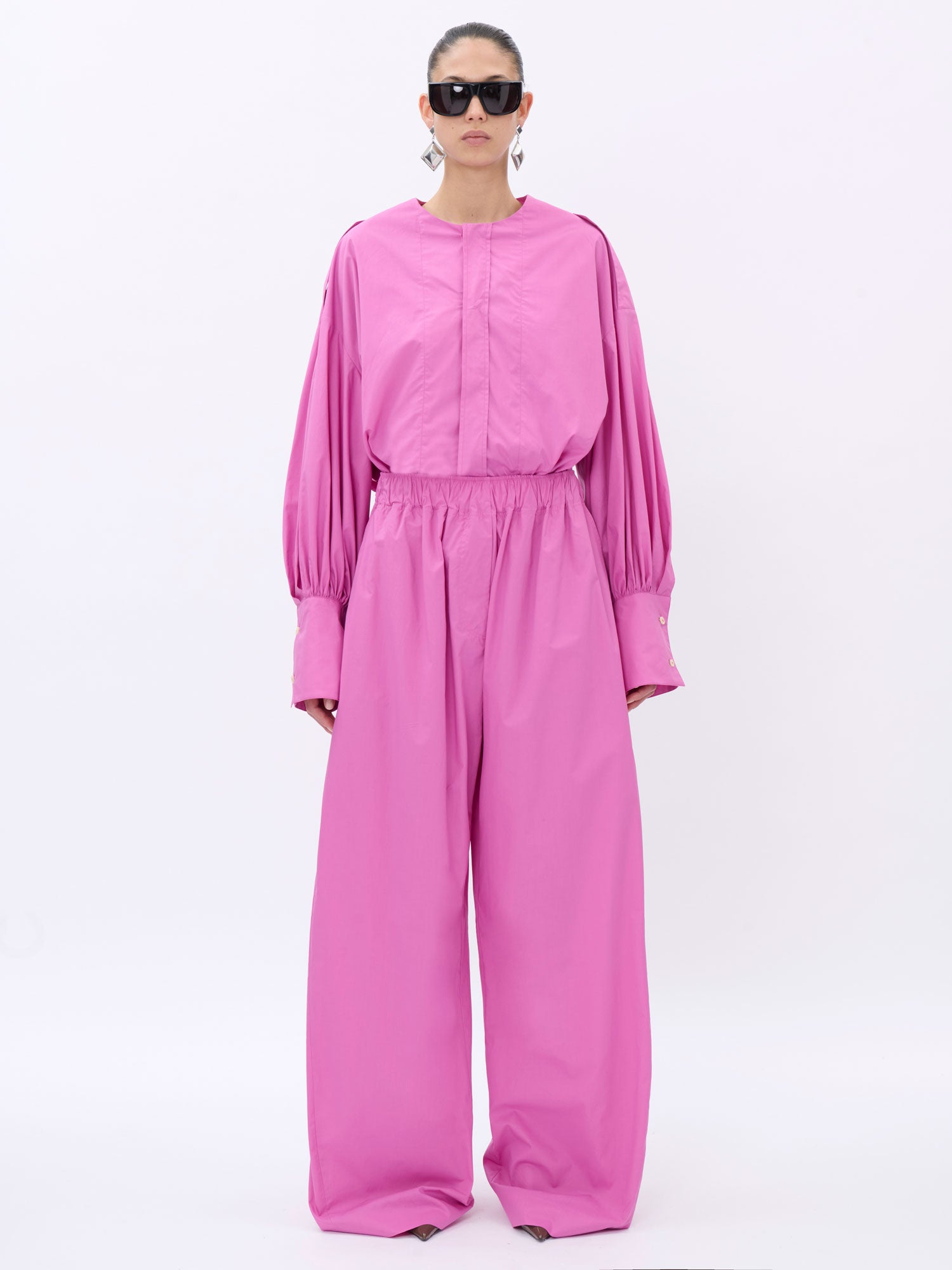 Person wearing a pink shirt on a white background