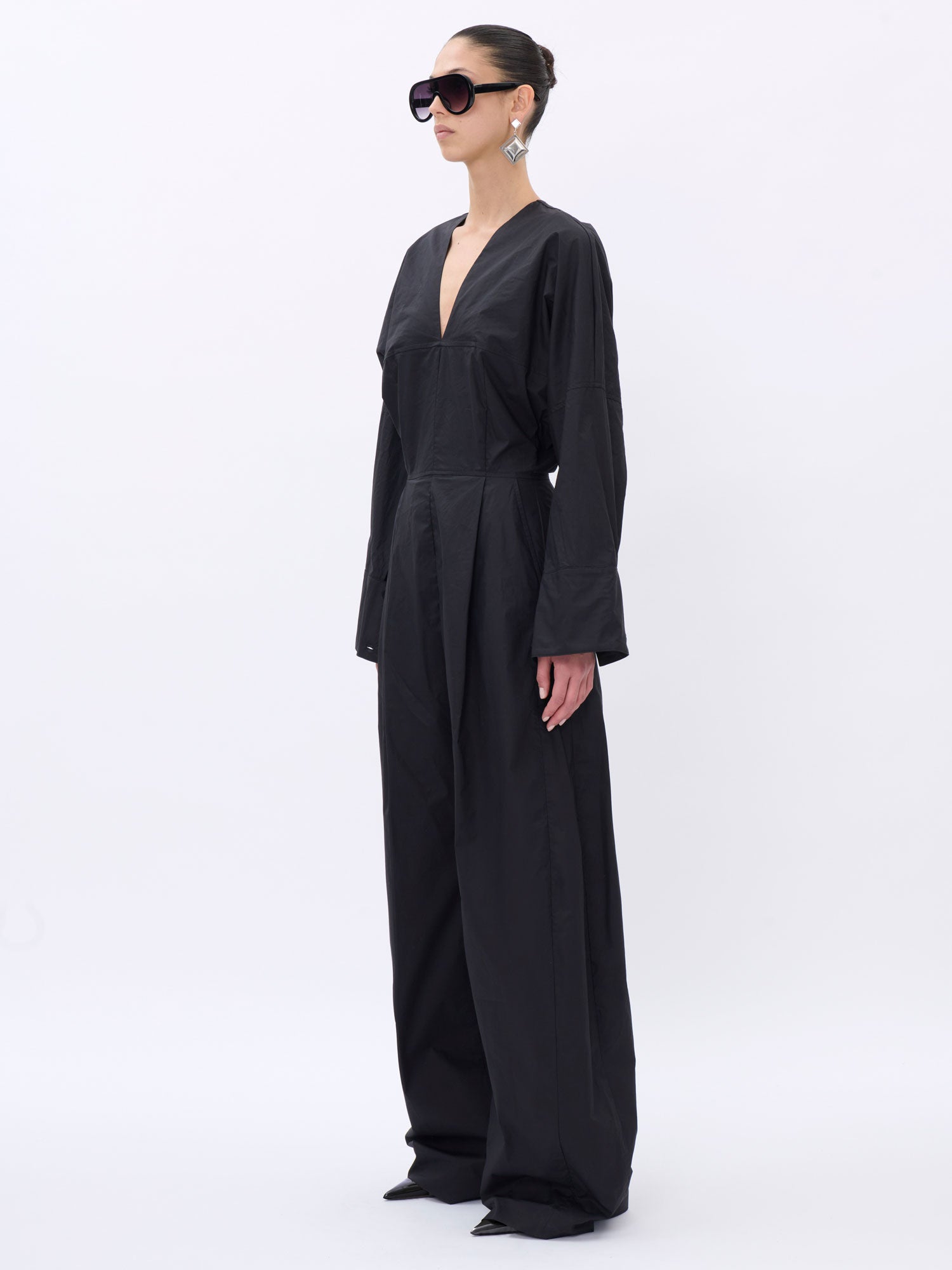 Woman wearing a black jumpsuit on a white background